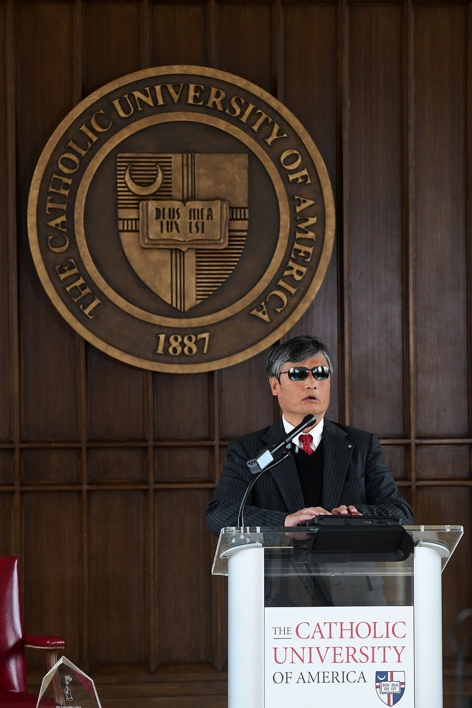 Chen Guancheng gives a speech at a podium in Heritage Hall at The Catholic University of America