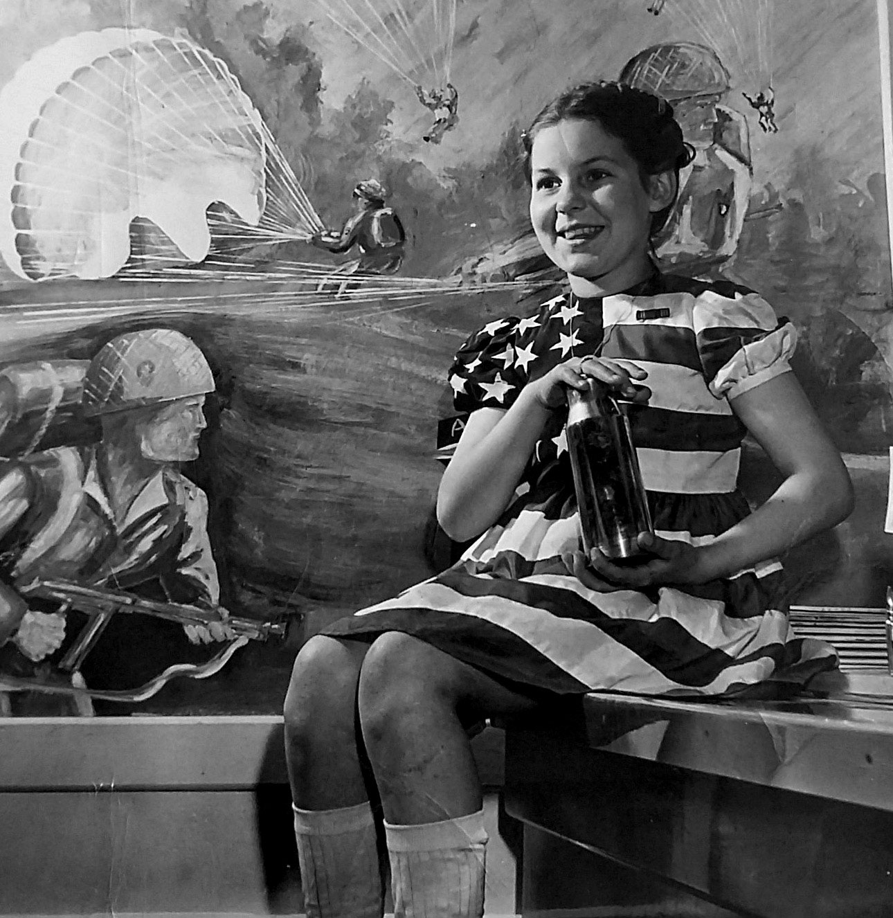 A black and white photo of a girl wearing an American flag dress