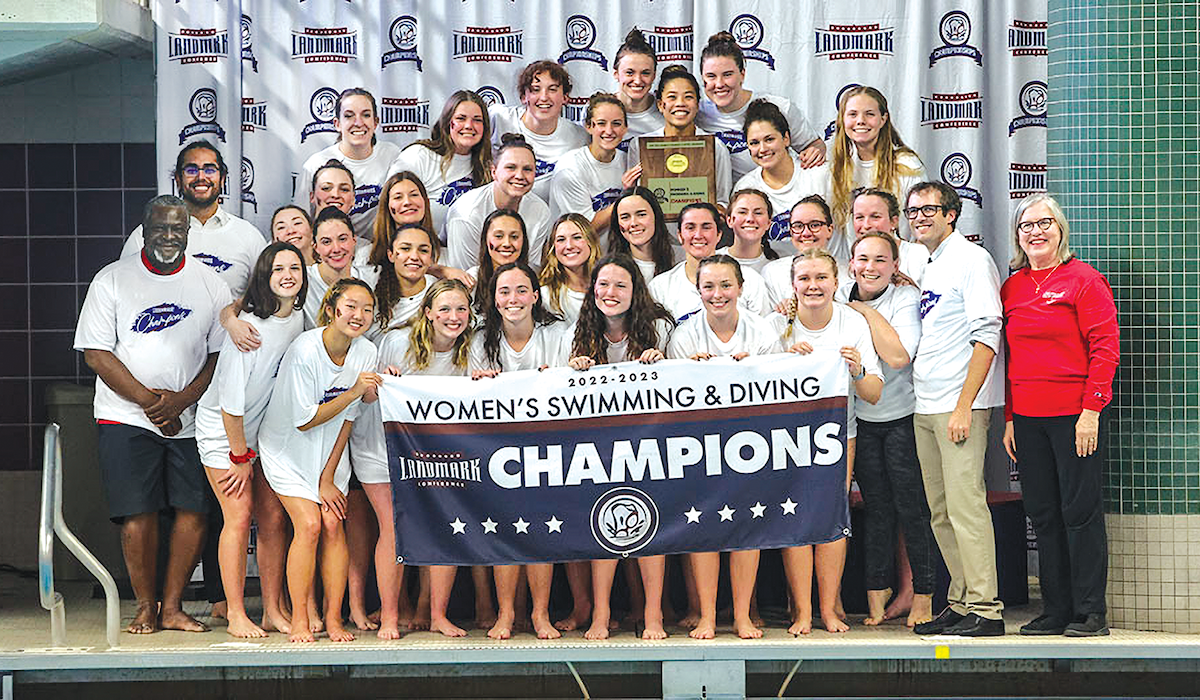 Women's swim and dive team posing with their championship poster