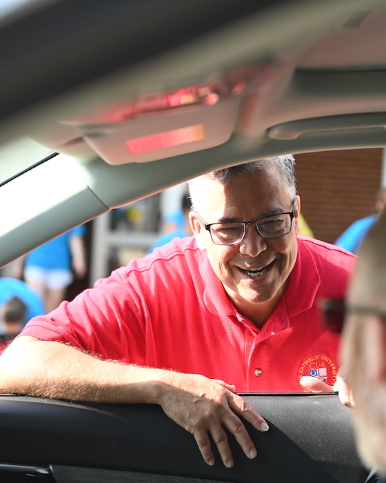 Dr. Peter Kilpatrick greets a parent at their car window as they arrive at move in day