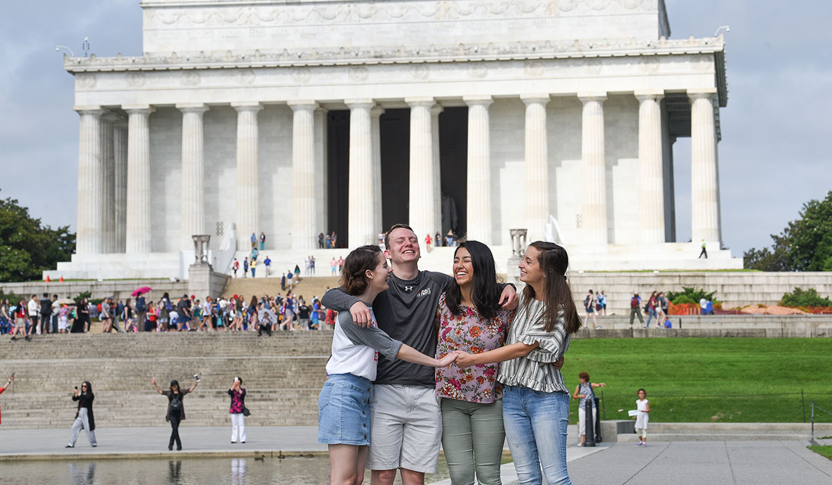 Students hugging in front of Lincoln Memorial 