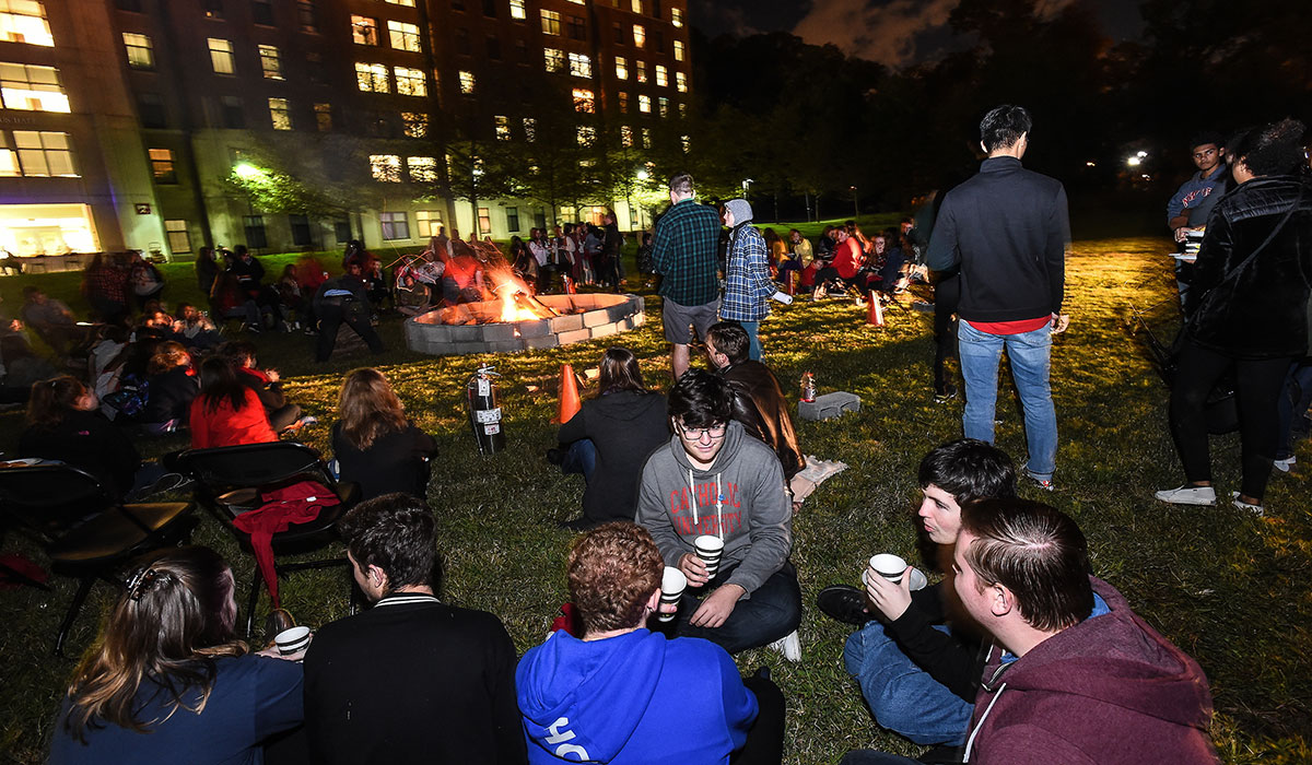 Students sitting around bonfire