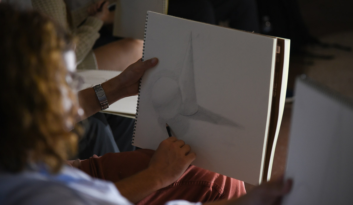 A business student sketching shapes during class