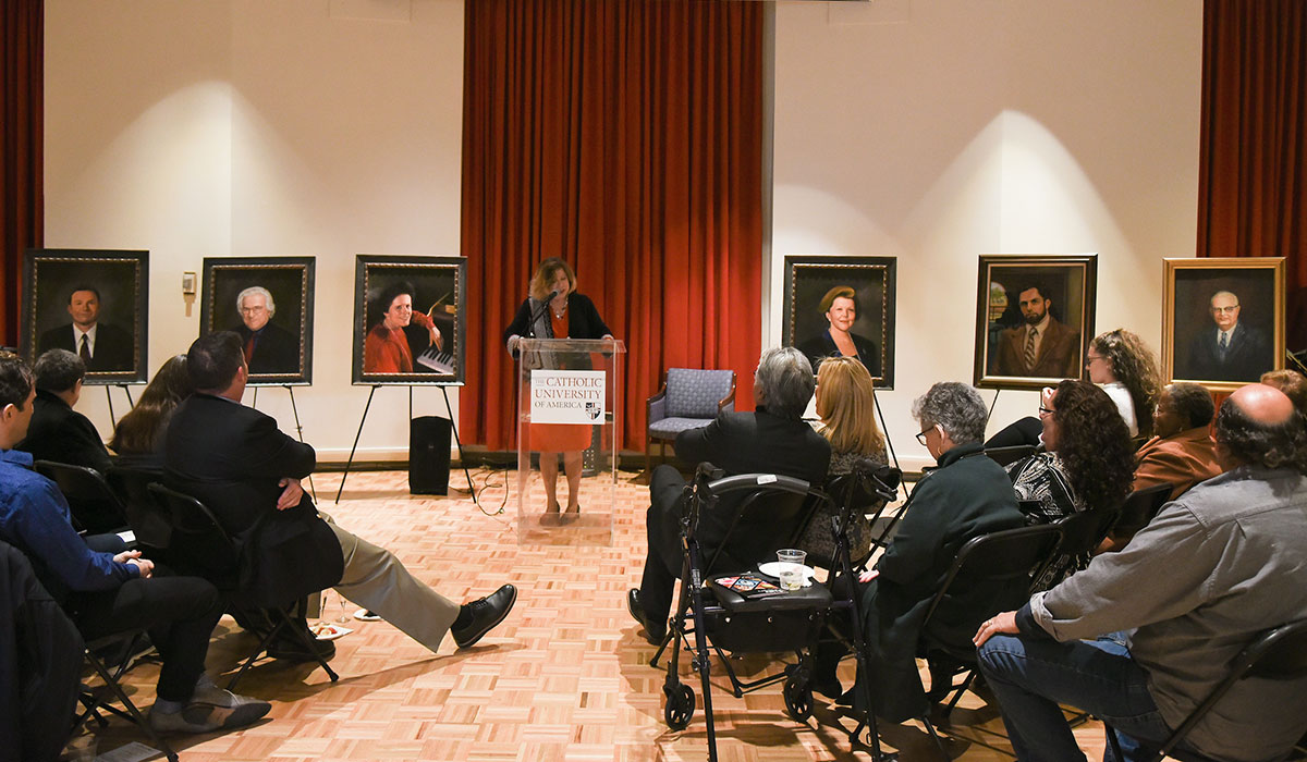 Jacqueline Leary-Warsaw speaks in front of all the portraits
