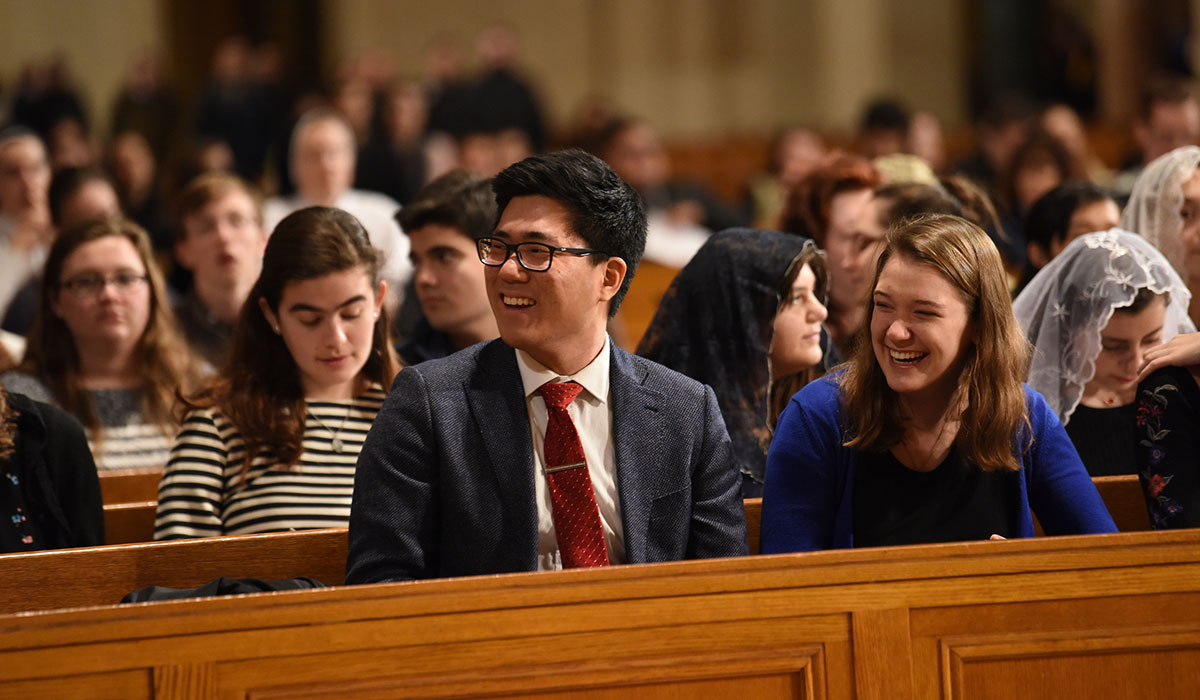 Students smiling in pews
