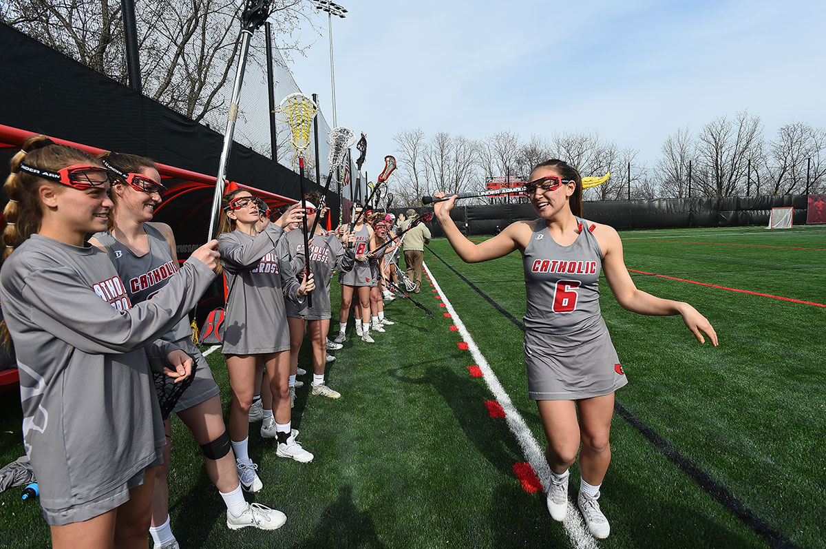 Female lacrosse players high fiving before a game