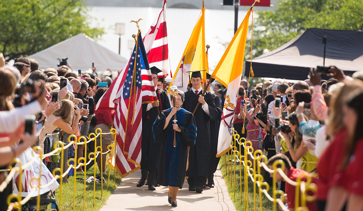 Druart leads the commencement procession carrying the mace