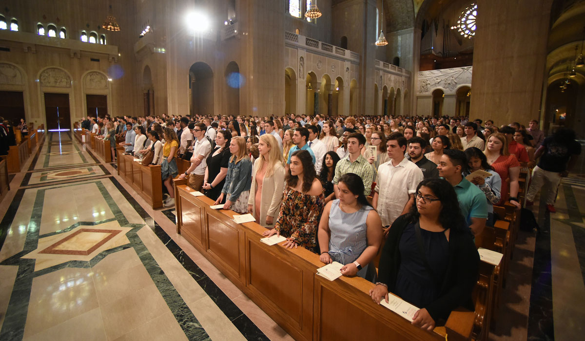 Students seated in the pews in the Basilica of the National Shrine of the Immaculate Conception