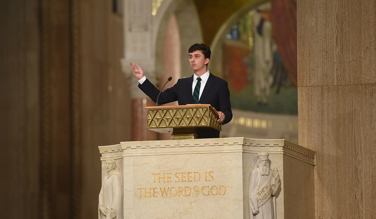 A student speaking at the mass