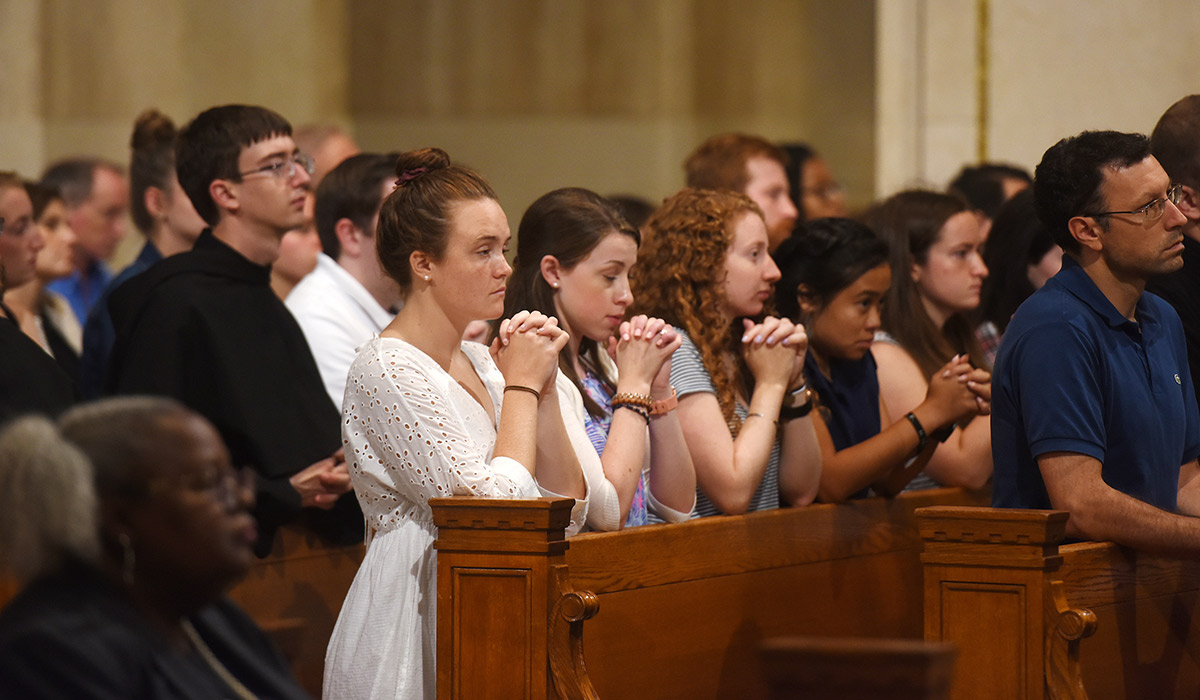 Students praying while attending mass