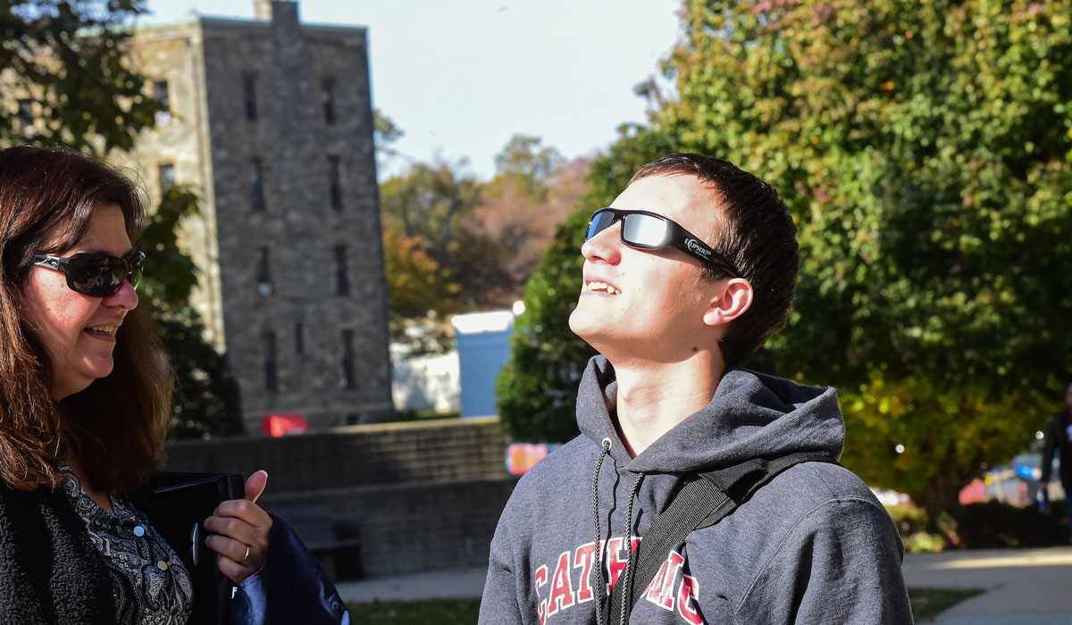 Male student looking at Mercury through sunglasses