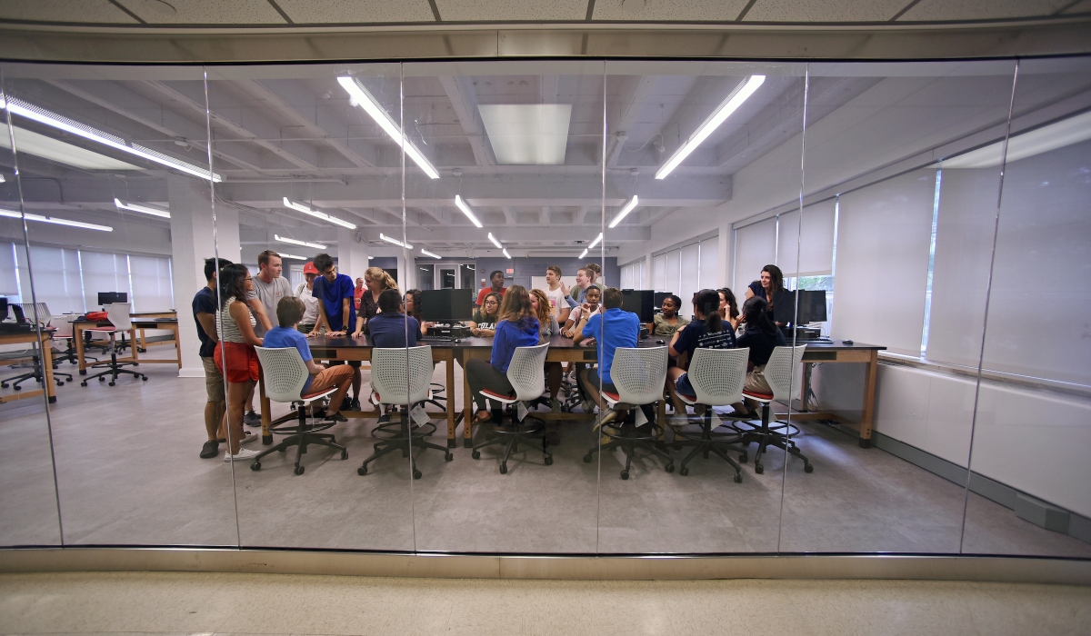 Interior of lab showing students sitting at desks as seen through large windows