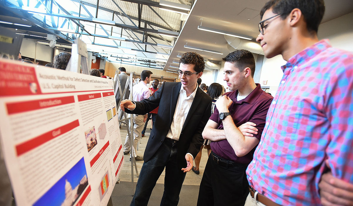 Male students presenting his poster