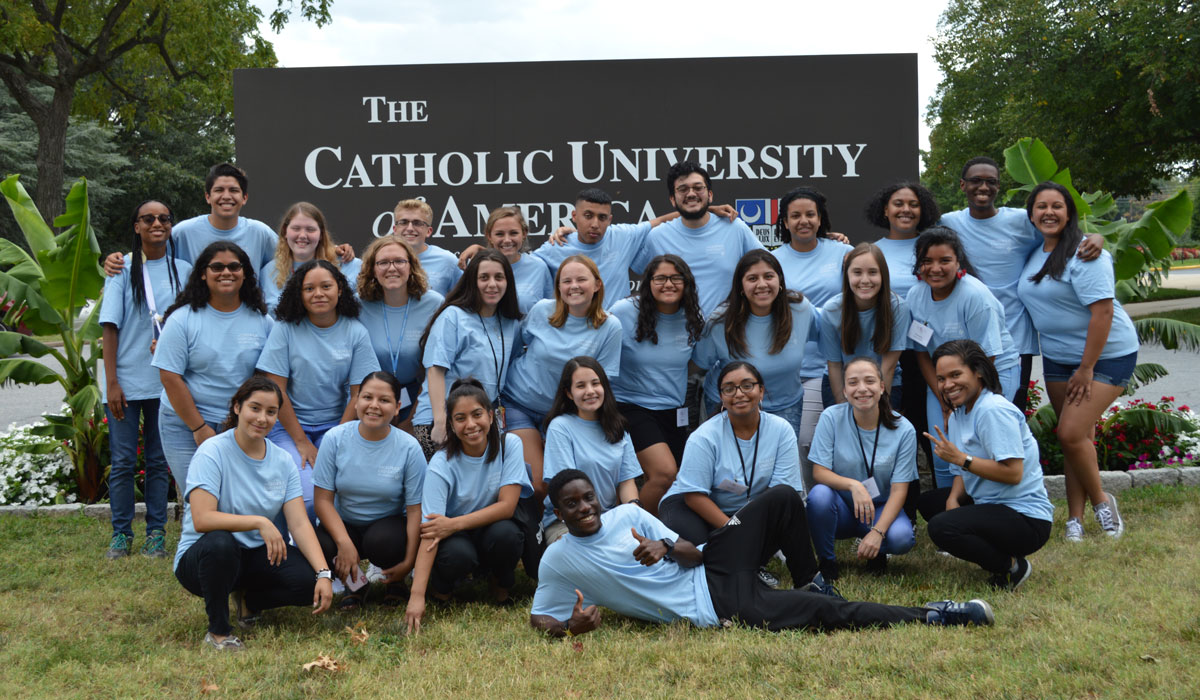 Students who took part in Take Flight Orientation program posing for a photo in front of a Catholic University sign