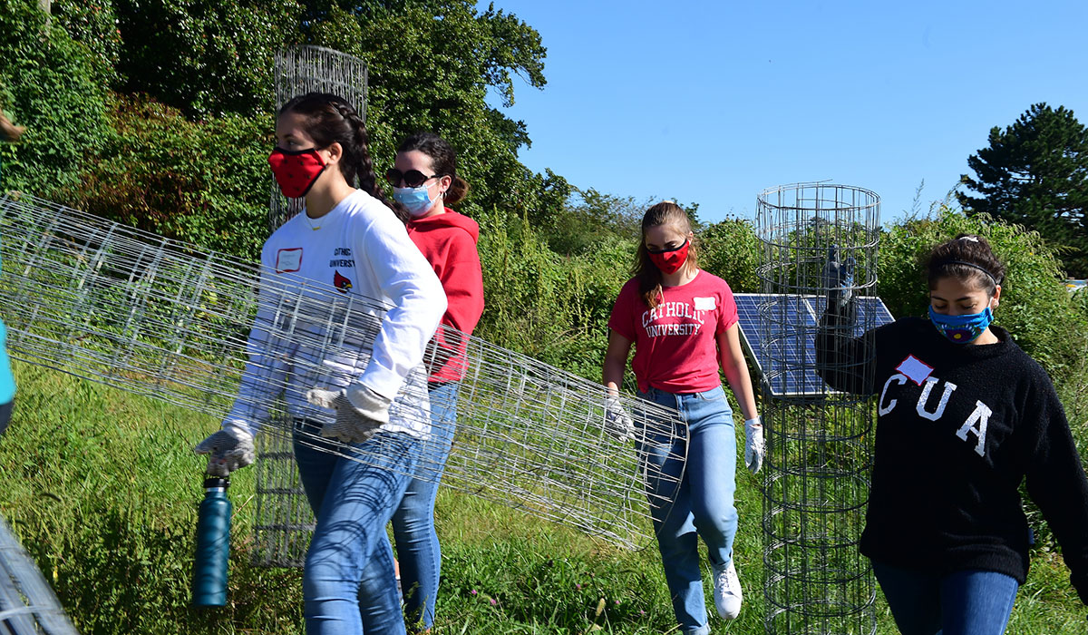 Students carrying wire fence