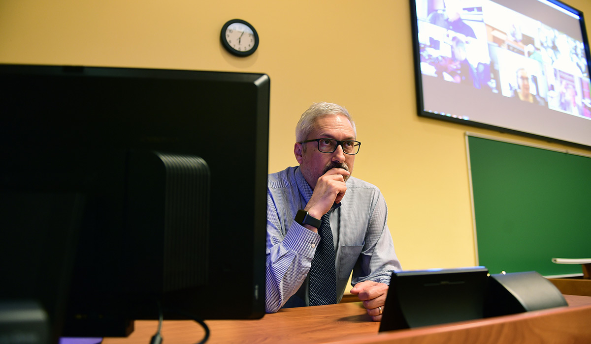 Provost sitting at desk in updated classroom