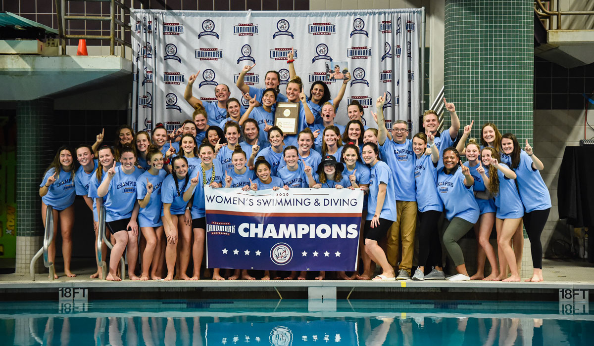 Women's swimming and diving team posing with championship banner