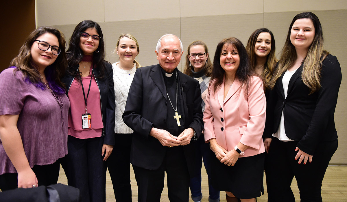 Archbishop Tomasi standing for a photo with students
