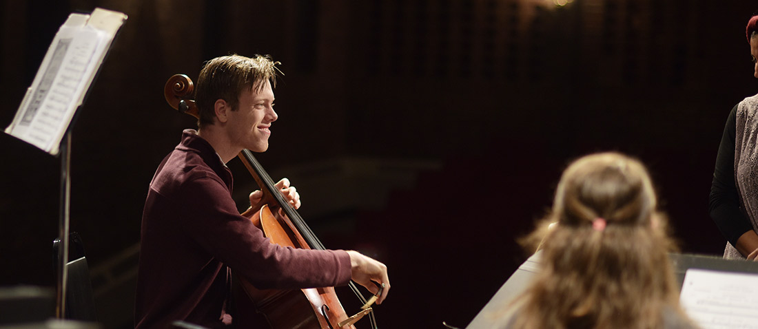 A student playing cello on stage
