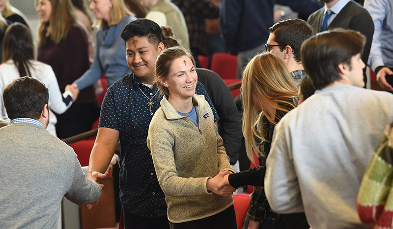 Female students with headscarves walking under a tree with red berries