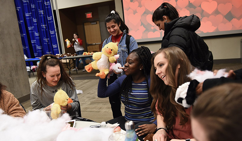 Statue of Mary in front of yellow trees with sunlight coming through branches