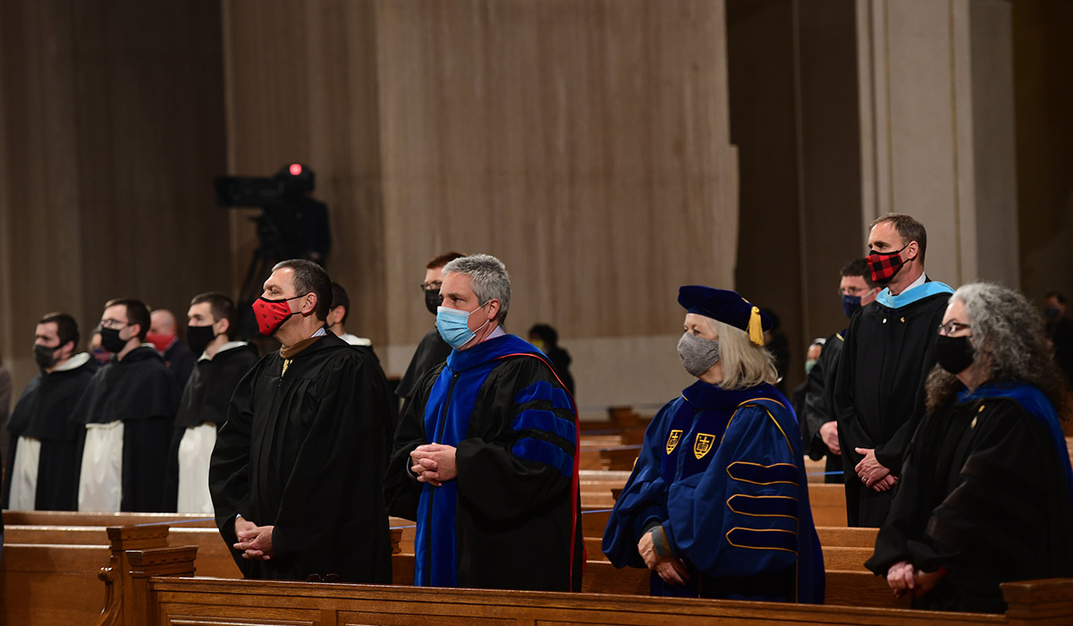 Faculty and other attendees standing and wearing masks