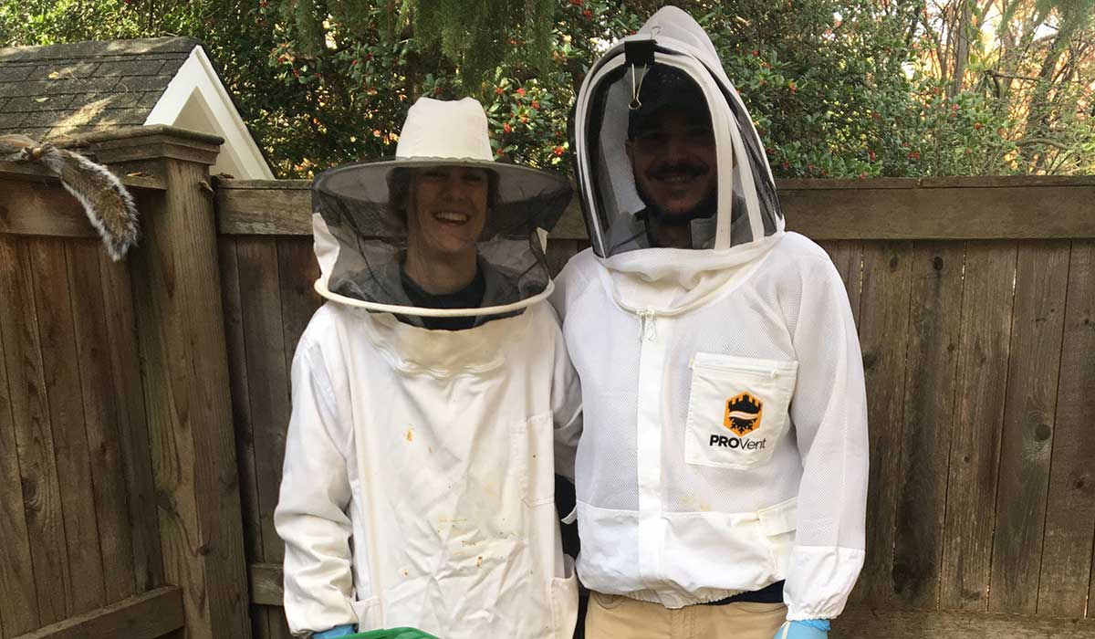 Students standing with their beehive