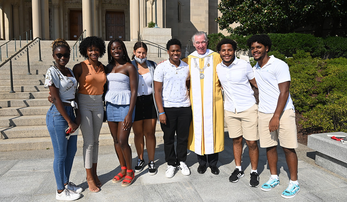 President Garvey posing with a group of students outside Basilica