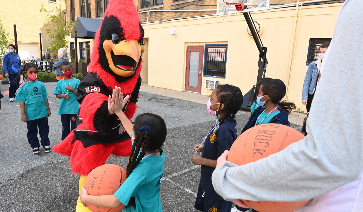 Children high-fiving Red the mascot
