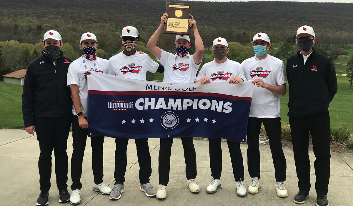 Men's golf team holding up championship banner and trophy