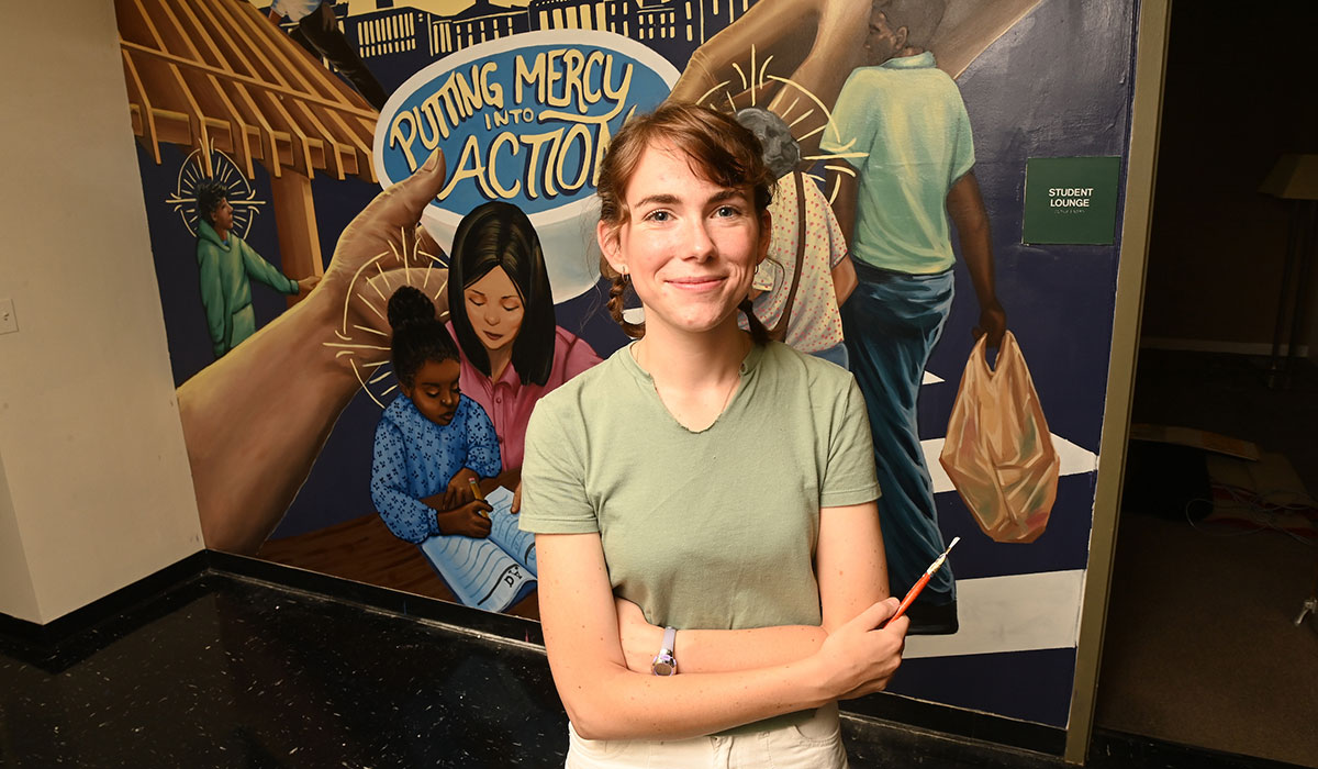 Joanie McMahon standing in front of the mural