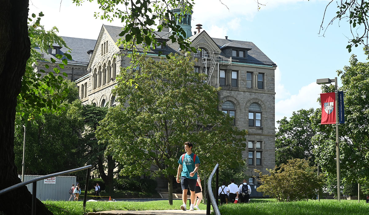Student walking in front of McMahon Hall