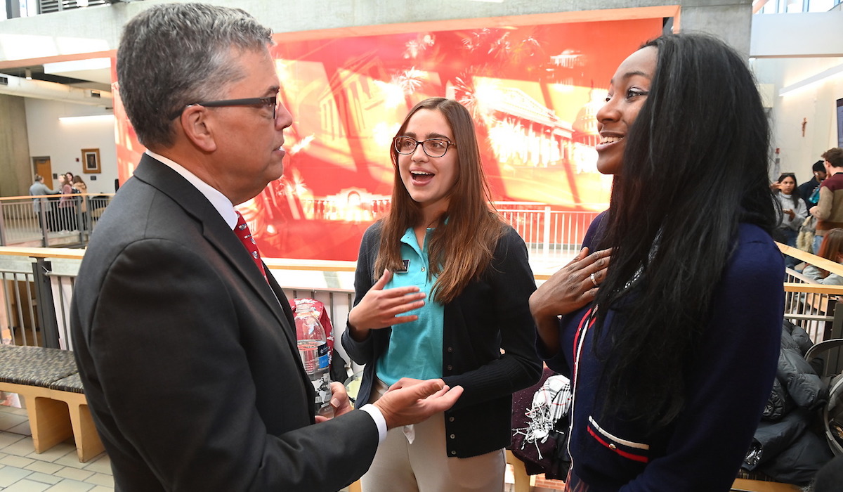 Peter Kilpatrick speaks with two female students