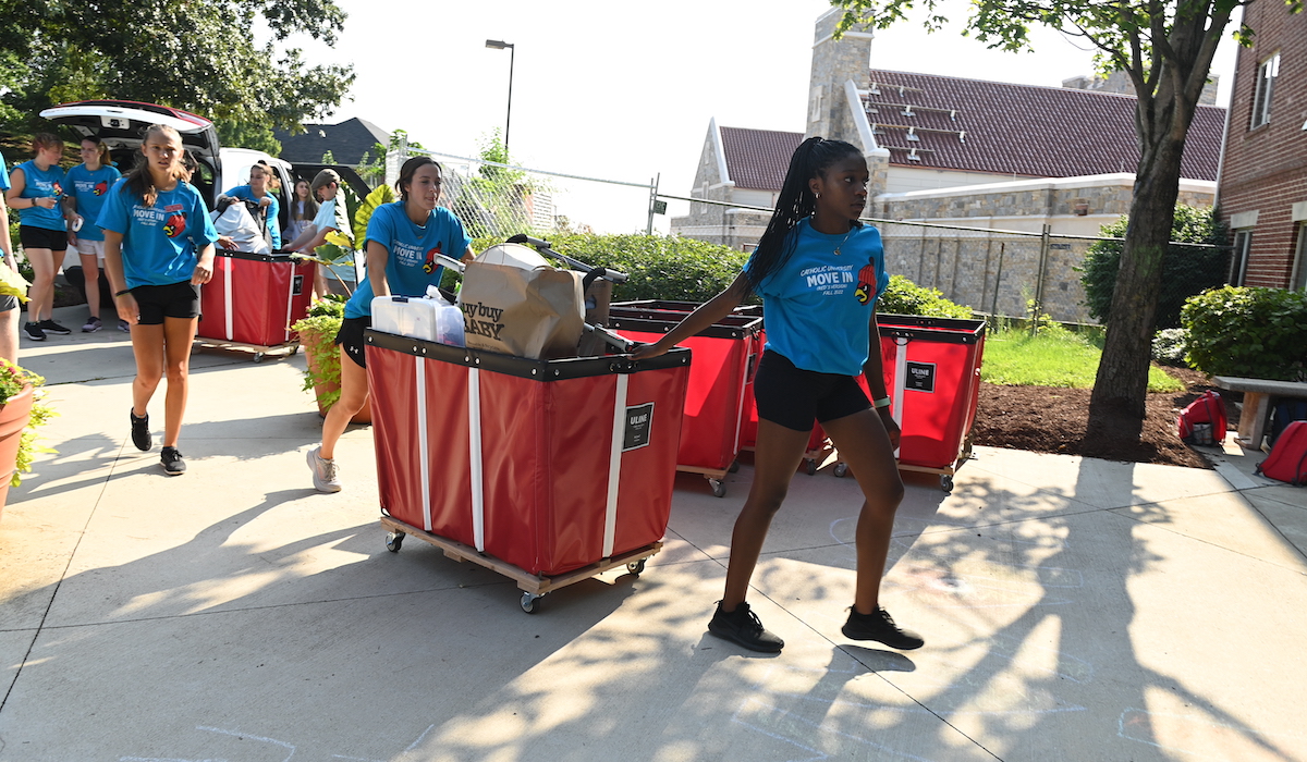 Orientation advisors help a student move into their dorm