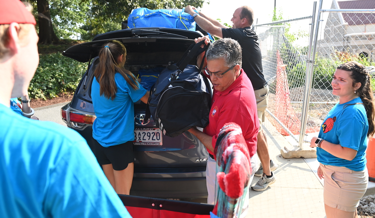 President Kilpatrick helps a family unload their car during move-in.