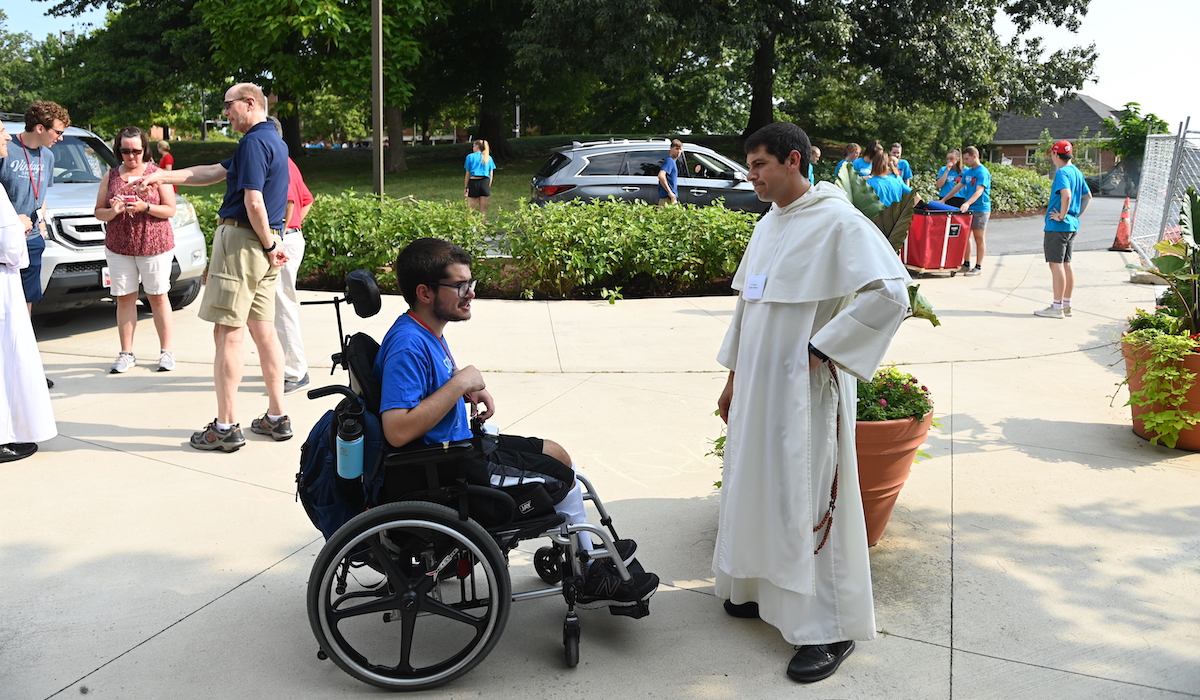 Campus Ministry Associate Chaplain Fr. Frassati Davis speaks with a new student.