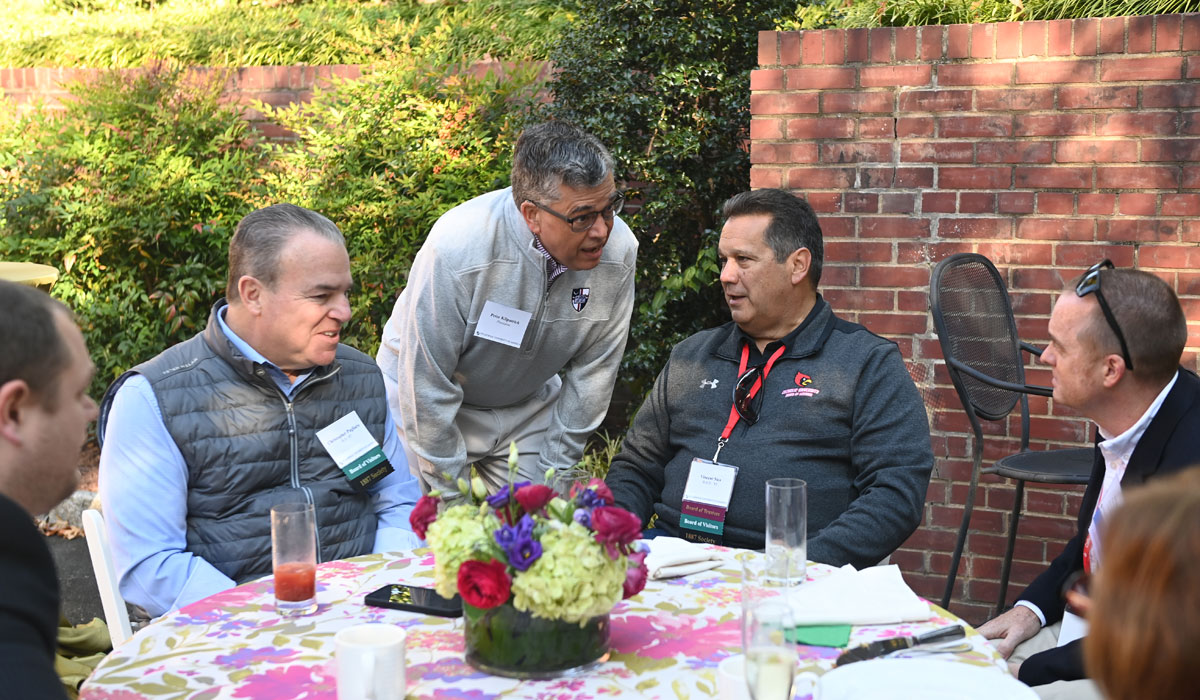 University President Dr. Peter Kilpatrick socializes with President’s Leadership Breakfast attendees