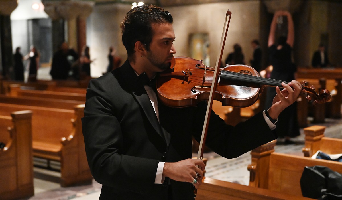 A violinist practices in the crypt church of the Basilica before the concert begins