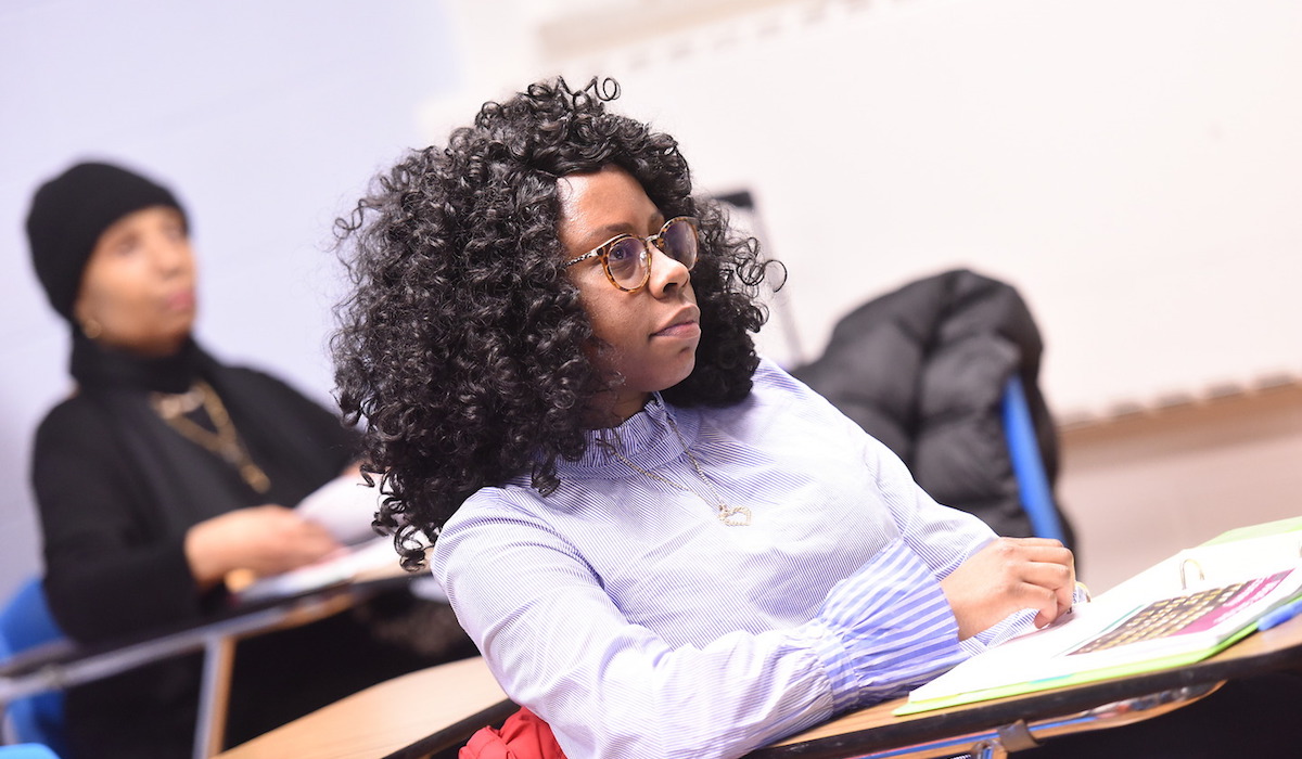 Student from the Metropolitan School of Professional Studies paying attention while her professor lectures in class.