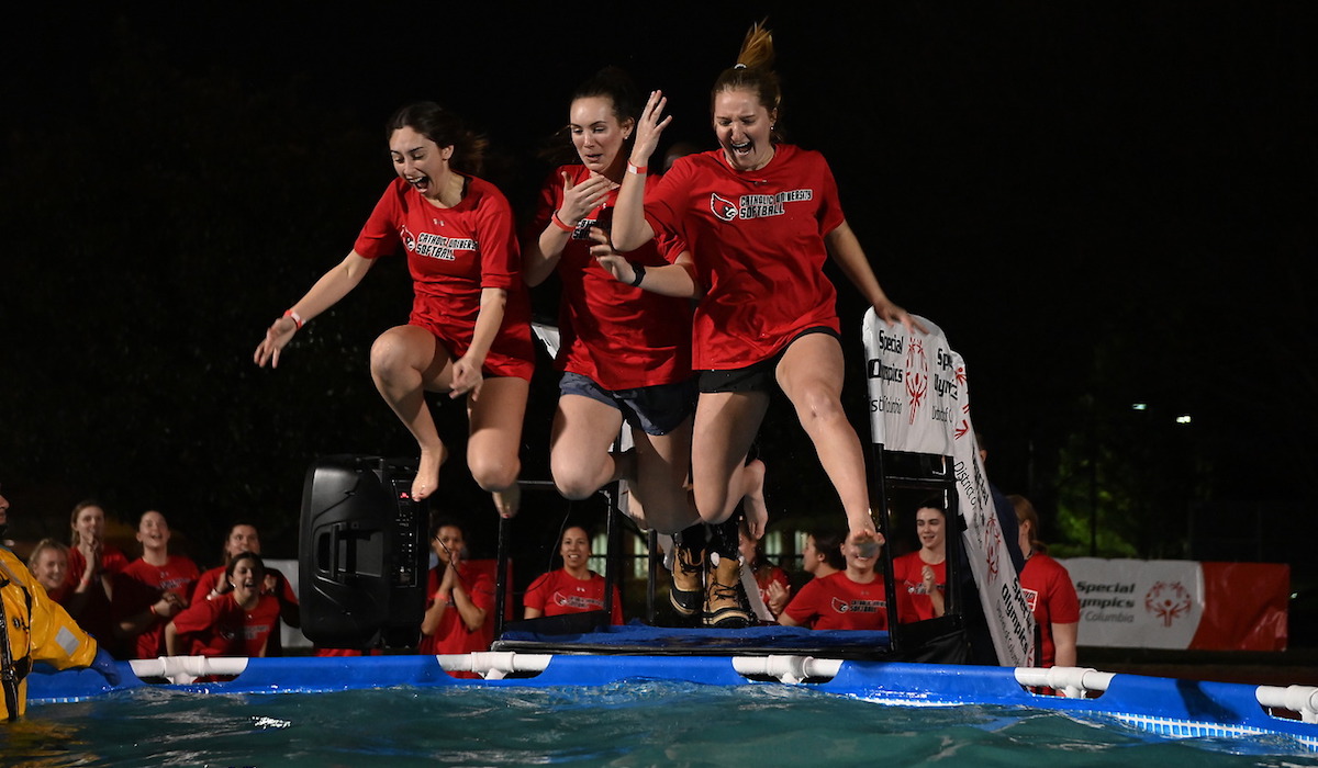 Three members of the Catholic University softball team jump into the polar plunge pool together