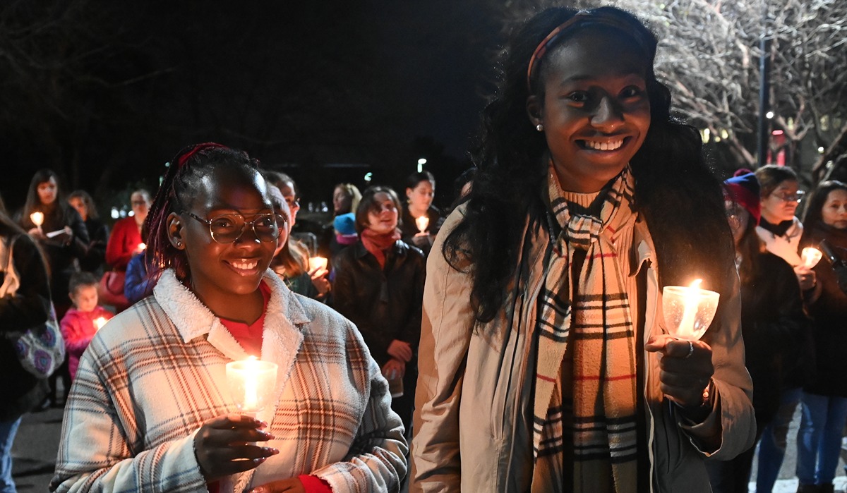 girls holding candles and smiling at the Christmas tree lighting