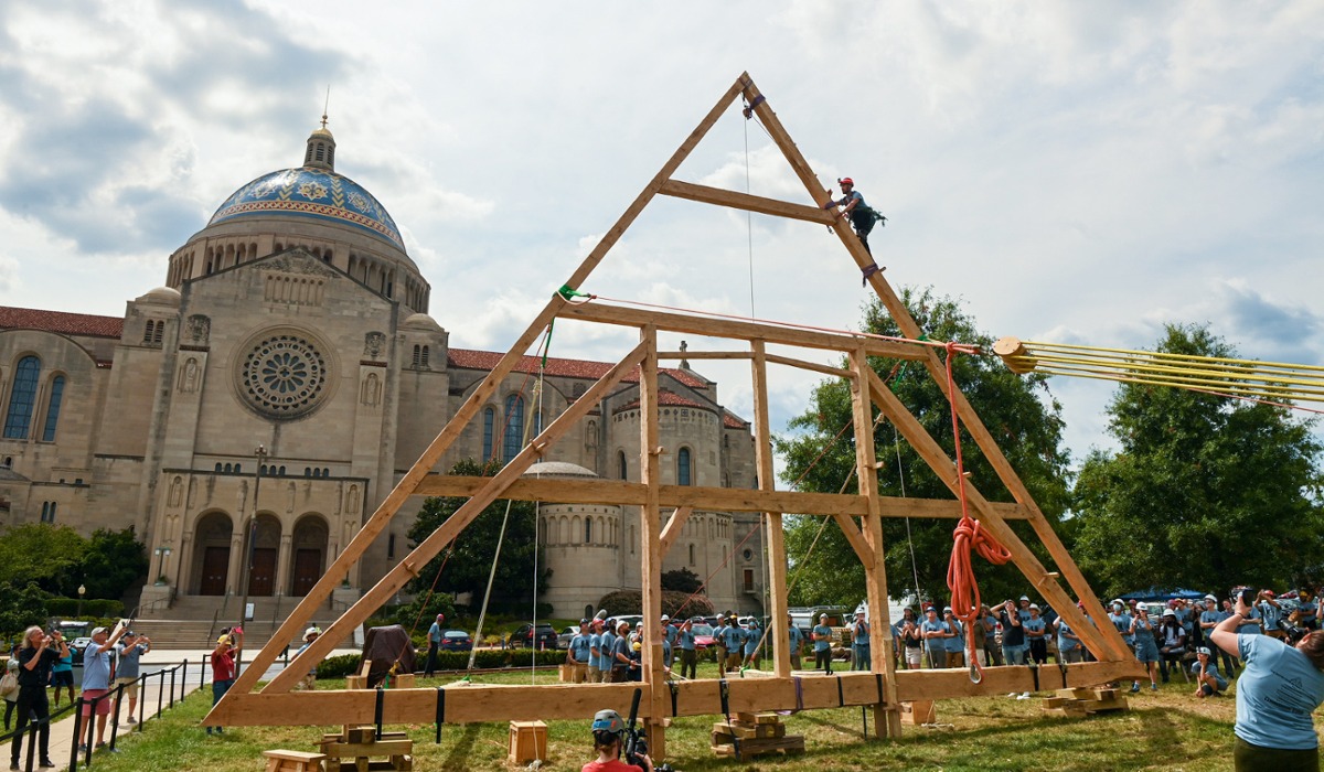 students and workers raising the truss