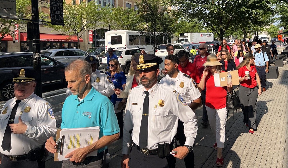 Leaders from Catholic University, D.C. law enforcement, and the local community walk down Monroe Street during a safety and security assessment of the campus perimeter July 25. 