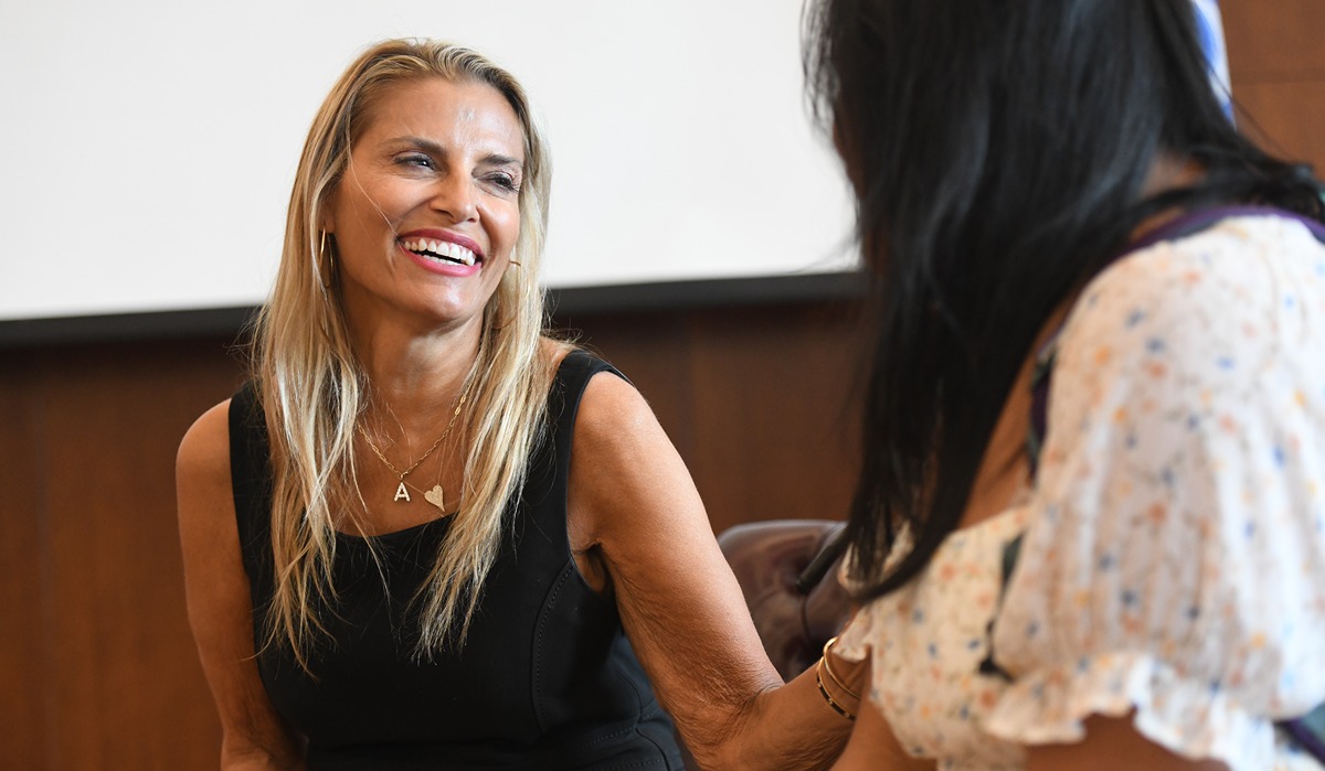 Angela Santomero laughing as she talks with a student