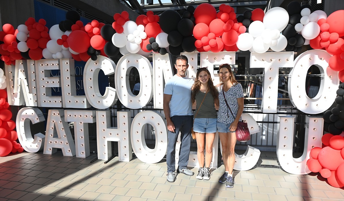 A student poses with her family inside the Edward J. Pryzbala University Center during Orientation weekend