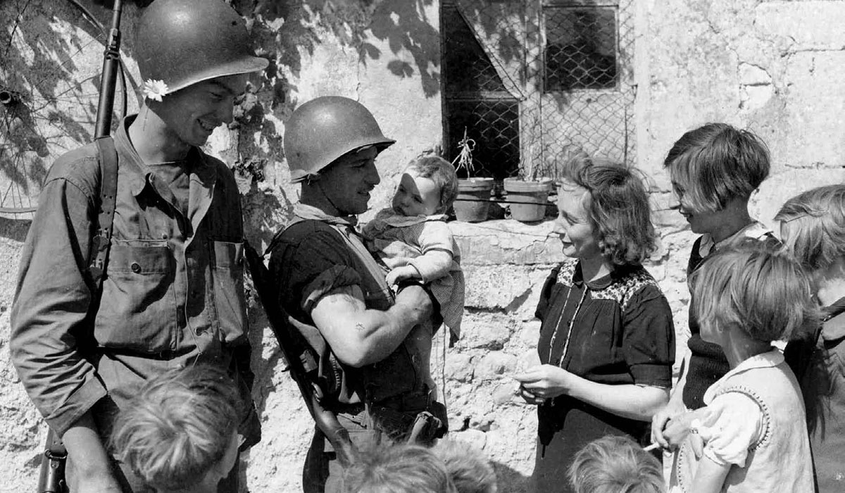 Historic photo of soldiers talking to citizens.