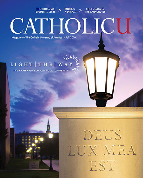 Cover of CatholicU Magazine showing an illuminated light and main walkway into campus