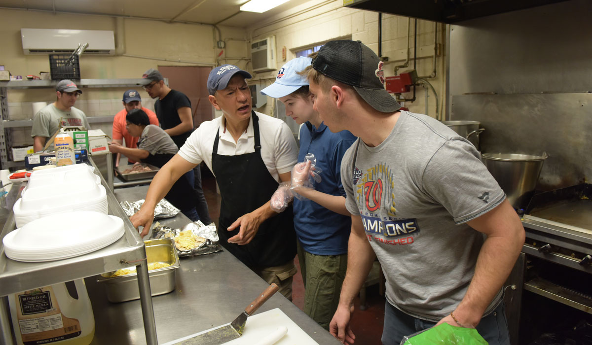 Students learning how to prepare food while volunteering