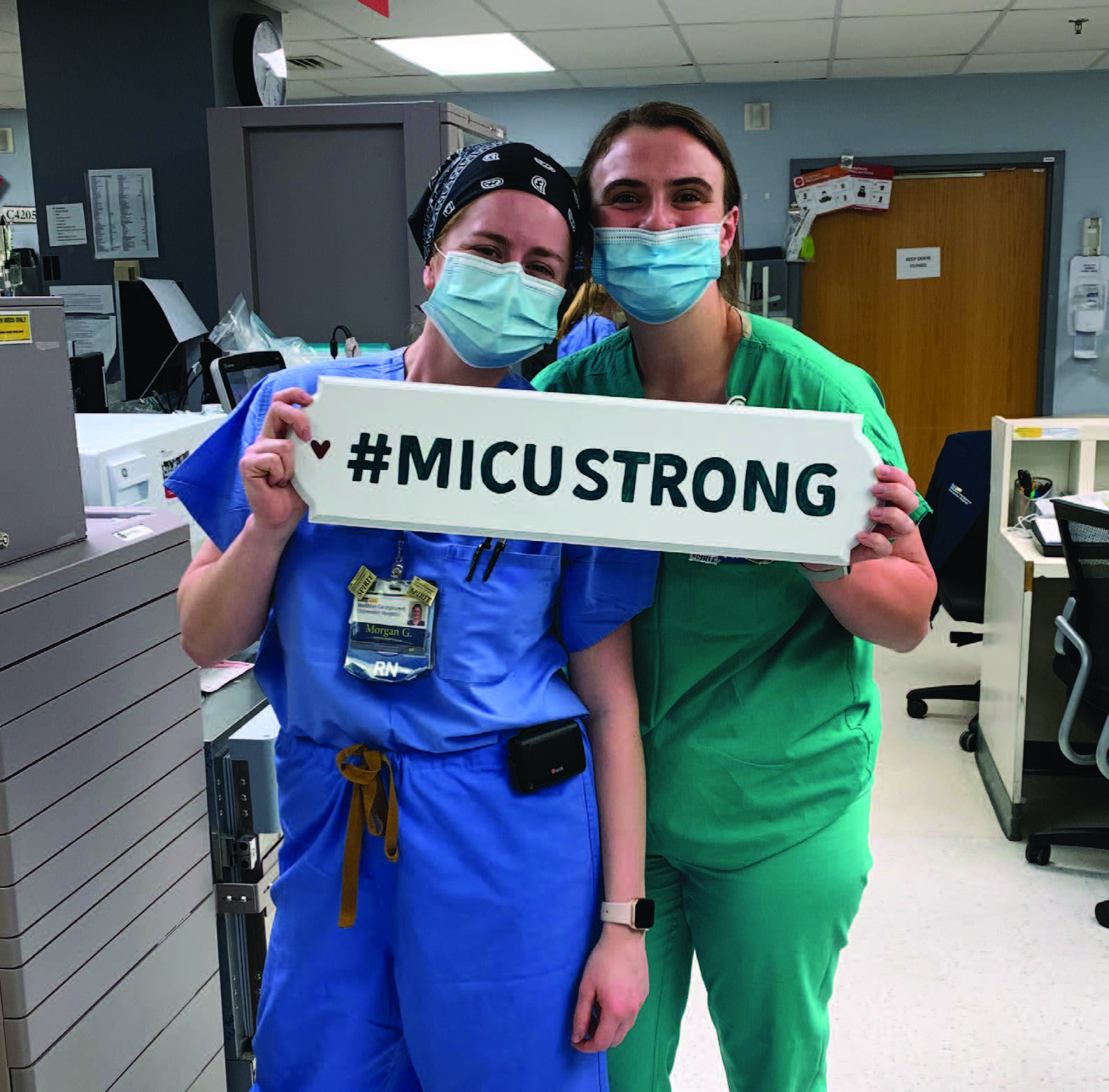 Morgan Gluck and a fellow nurse holding a sign that reads #MICUSTRONG.jpg