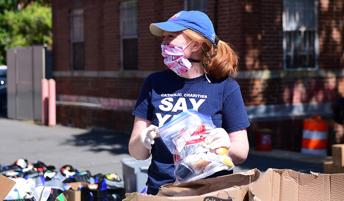 Alumna Bridget Maley prepares a bag of food to distribute
